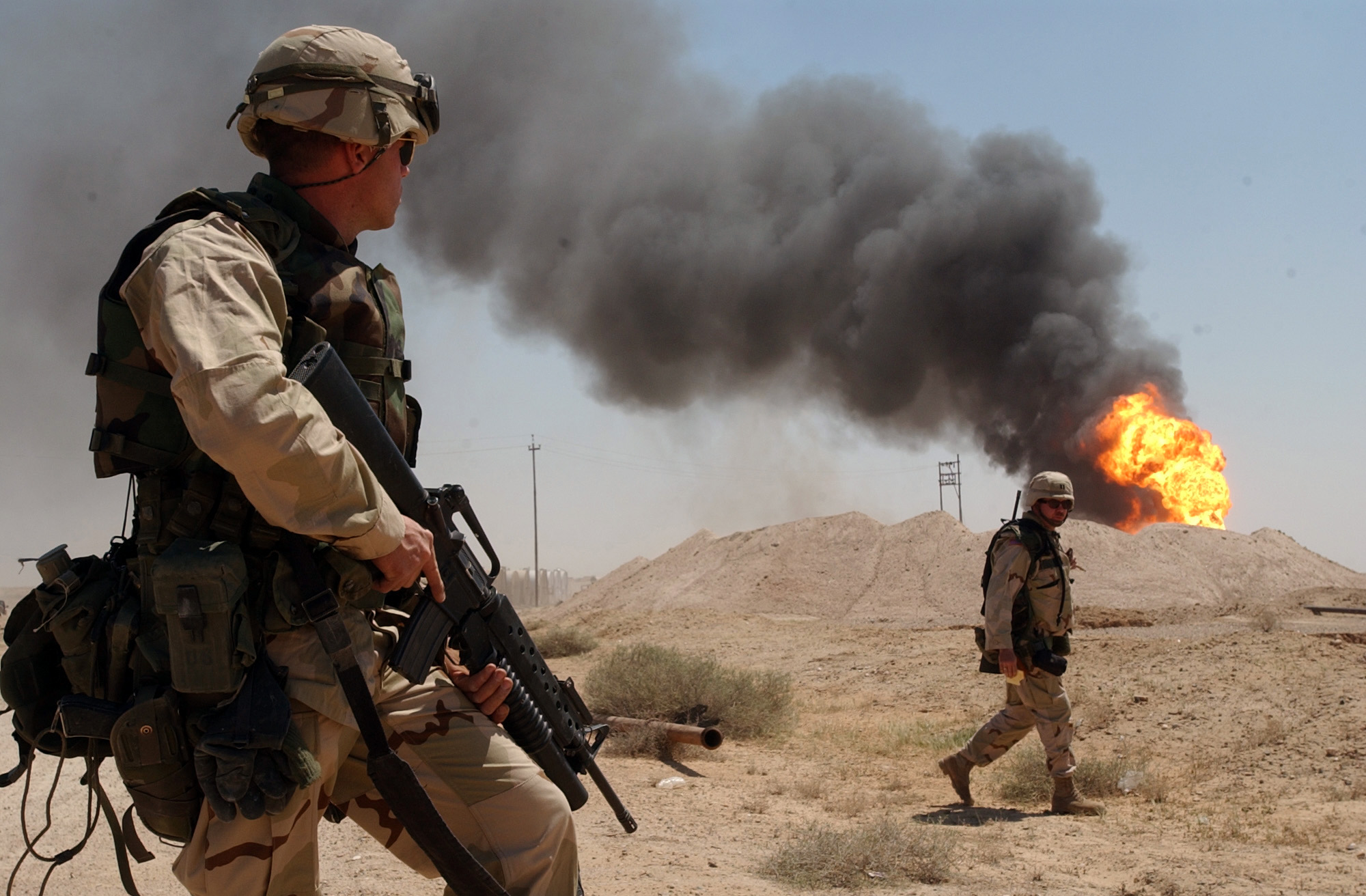 US_Navy_030402-N-5362A-004_U.S._Army_Sgt._Mark_Phiffer_stands_guard_duty_near_a_burning_oil_well_in_the_Rumaylah_Oil_Fields_in_Southern_Iraq