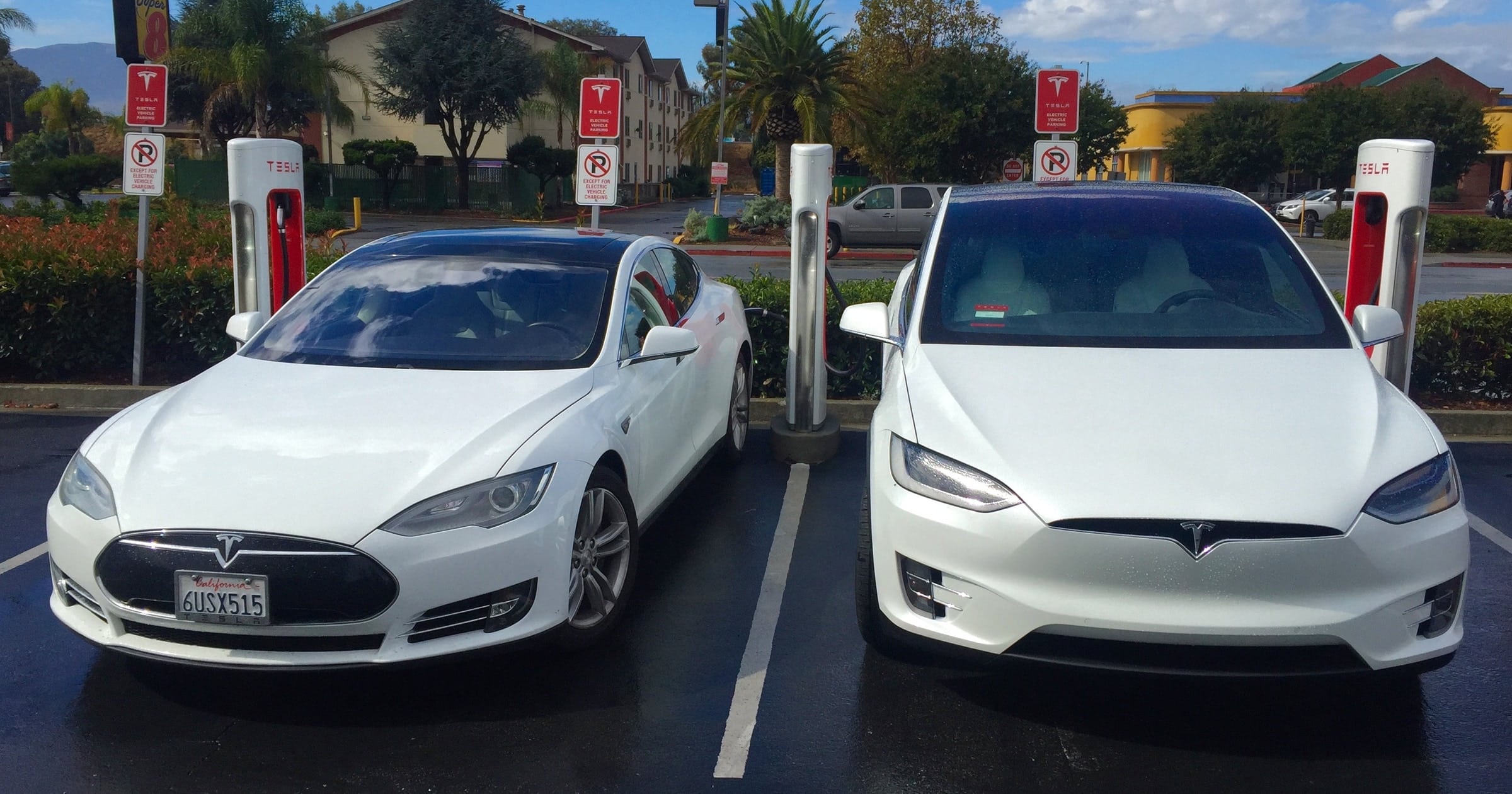 two-white-electric-vehicles-teslas-at-a-supercharger-the-one