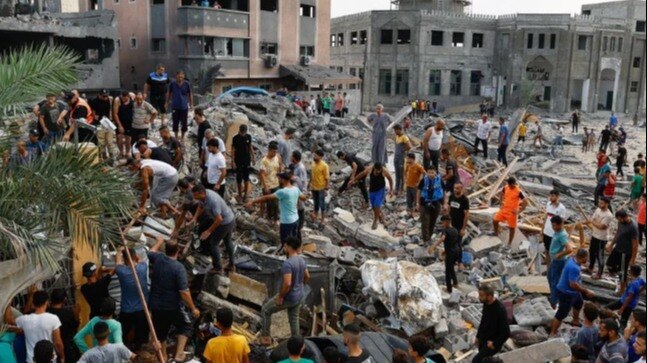 palestinians-walk-among-the-rubble-of-a-building-destroyed-in-israeli-strikes--in-the-southern-gaza-14333669-16x9