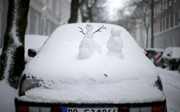 آدم برفی ها در هنگام بارش برف در دورتموند آلمان بر روی اتومبیل پوشیده از برف دیده می شوند. 