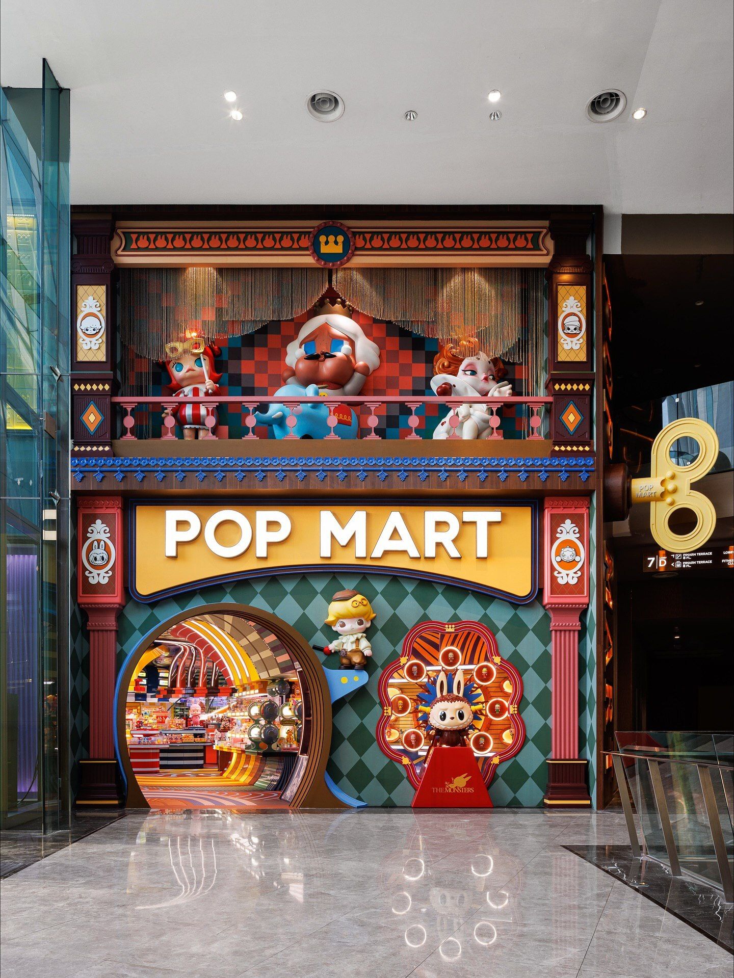 تصاویری از فضای داخلی فروشگاه پرچمدار برند پاپ مارت (POP MART) در مرکز خرید آیکون سیام بانکوک، که توسط استودیوی X+Living با طراحی مفهومی و الهام از نقوش معبد وات آرون تایلند اجرا شده و دارای فضای پیکسلی و کافه «داستان پریان» است.