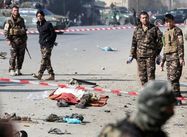 نیروهای امنیتی افغانستان پس از انفجار در کابل ، در نزدیکی جسد مرده یک قربانی بازرسی می کنند. 
