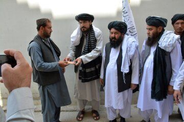 طالبان در حال توزیع دلار بین مردم افغانستان+عکس 